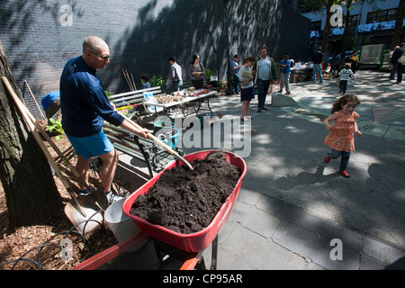 Freiwillige Blumen Pflanzen und eine allgemeine Aufräumen von Spielplatz im Stadtteil Chelsea in New York Stockfoto