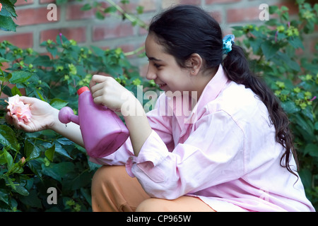 kleines Mädchen Blumen im Garten gießen Stockfoto
