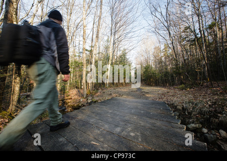 Wanderer auf Trail überqueren Holzbrücke Stockfoto