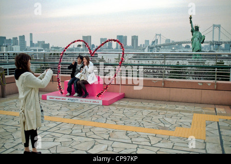 Ein Liebespaar vor der Bucht von Tokio, Odaiba. Rainbow Bridge und eine Replik der Statue of Liberty, Japan Stockfoto