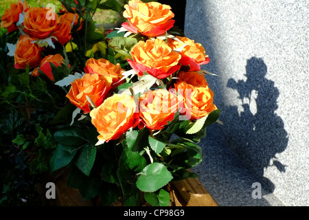 Blumen auf ein Grab auf einem Friedhof Stockfoto