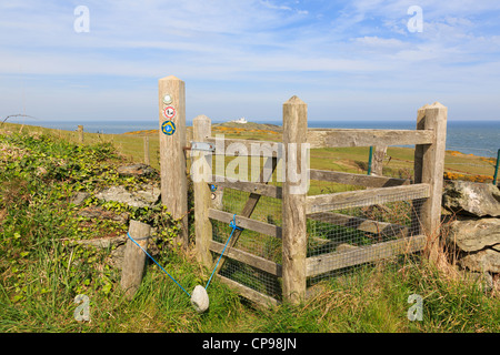 Hölzerne Tor auf dem Isle of Anglesey Küstenpfad mit Point Lynas jenseits küssen. Llaneilian Anglesey North Wales UK Stockfoto