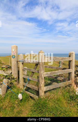 Hölzerne Tor auf dem Isle of Anglesey Küstenpfad mit Point Lynas jenseits küssen. Llaneilian Anglesey North Wales UK Stockfoto