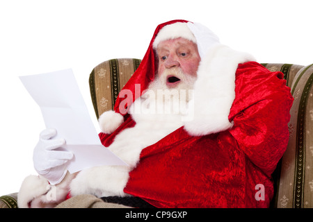 Santa Claus in authentischen Look Wunschliste mit überrascht Gesichtsausdruck lesen. Alle auf weißem Hintergrund. Stockfoto