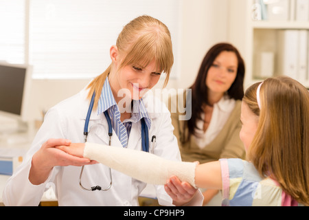 Weibliche Kinderarzt überprüfen Verband der gebrochenen Arm Mädchen Stockfoto