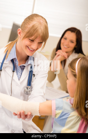 Weibliche Kinderarzt überprüfen Verband der gebrochenen Arm Mädchen Stockfoto