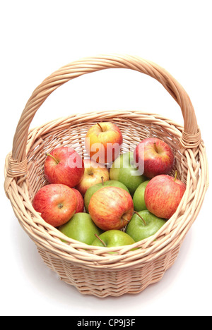 Ein Korb gefüllt mit grünen und roten Äpfeln auf weißem Hintergrund Stockfoto