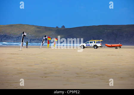 Die RLNI Rettungsschwimmer bewacht Surfer an Perranporth, Cornwall, England, Vereinigtes Königreich Stockfoto