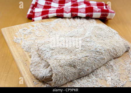 Stufe 4 bei der Vorbereitung einer kneten Handwerker Sauerteigbrot, den gestreckten Teig falten. Stockfoto