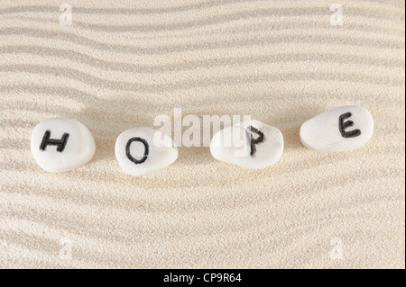 Hoffe Wort auf Gruppe von Steinen mit Sand als Hintergrund Stockfoto