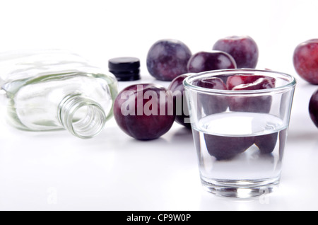 Pflaumenschnaps in ein kleines Glas und frische Pflaumen Stockfoto