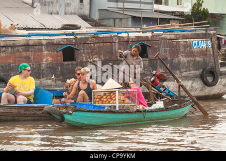 Touristen-Kauf von Lebensmitteln in den schwimmenden Markt, Cai Rang in der Nähe von Can Tho, Mekong-Fluss-Delta, Vietnam Stockfoto