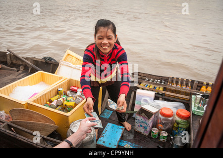 Junges Mädchen, Verkauf von Getränken von einem Boot in der schwimmende Markt Cai Rang in der Nähe von Can Tho, Mekong-Fluss-Delta, Vietnam Stockfoto