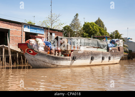 Voll beladene Frachtschiff vor Anker neben einem Gebäude, Vinh Long, Mekong-Fluss-Delta, Vietnam Stockfoto