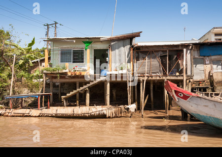 Riverside Häuser unterstützt von Stelzen, in der Nähe von Cai Be und Vinh Long, Mekong-Fluss-Delta, Vietnam Stockfoto