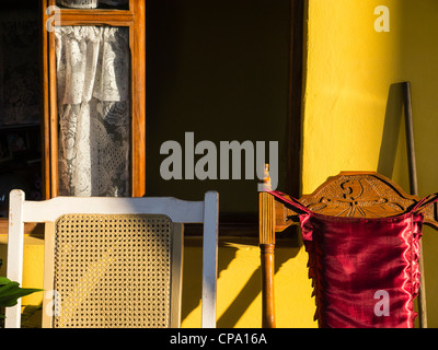 Zwei sehr unterschiedliche Stil der Stuhllehnen und Fensterrahmen mit Spitzevorhang bieten eine Studie in verschiedenen Texturfarbe in Kuba. Stockfoto