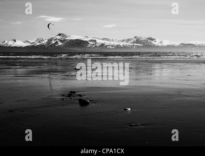 Kitesurfer auf einem Alaskan Strand bei Ebbe in der Nähe von Homer Alaska in schwarz und weiß. Stockfoto