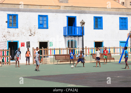 Lokale Jungen, die auf dem Spielplatz am Hauptplatz barfuß Fußball spielen. Largo Santa Isobel, Sal Rei, Boa Vista, Kapverdische Inseln Stockfoto