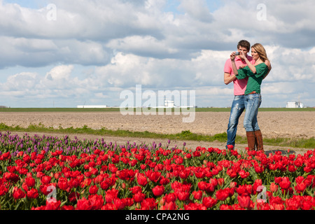 Junges Paar nimmt Bilder in Holland von Blumenwiesen Stockfoto