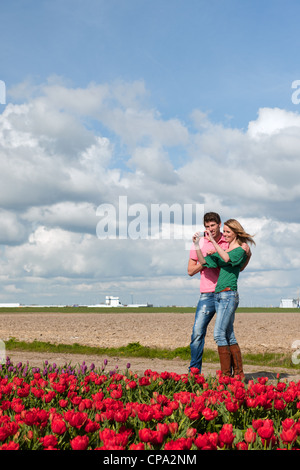 Junges Paar nimmt Bilder in Holland von Blumenwiesen Stockfoto