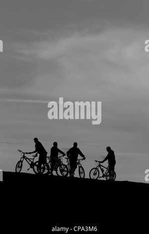 Gruppe von Mountainbikern auf Hügel bei Dämmerung, England, UK Stockfoto