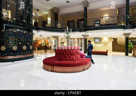 reich verzierte Art-Deco-Atrium des alten Luxushotel mit dekorativen Eisen Geländer Aufzug Welle tiffanyglas Aufzug Fahrerhaus Zeitraum Dekor Stockfoto