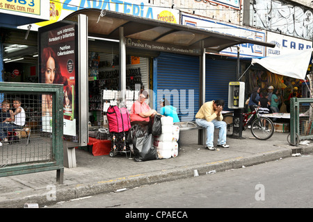 drei mexikanischen Normalbürger Mexikaner warten auf Bus Haltestelle auf überfüllten Bürgersteig in Centro Viertel-Mexiko-Stadt Stockfoto