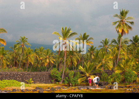 Hawaii, Big Island, South Kona, Pu'uhonua o Honaunau National Historical Park. Besucher und Felswand. Stockfoto