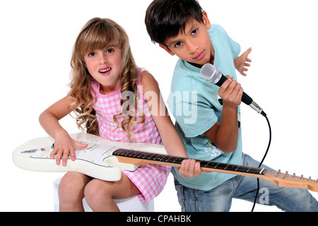 Kinder, die vorgeben, in einer Rockband zu sein Stockfoto