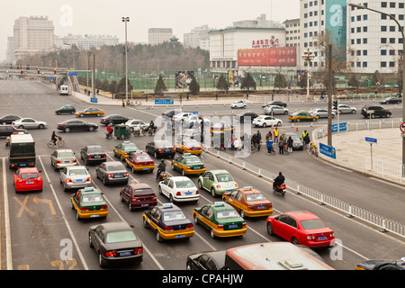 Morgendlichen Berufsverkehr in Peking, China, mit Autos, Fahrräder und die Umweltverschmutzung, für die die Stadt berühmt-berüchtigten ist Stockfoto