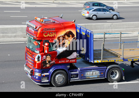 Johnny Cash LKW-Kunstgrafiken auf Seitenansicht der Sattelzugmaschine Scania mit Sattelzugmaschine und Tieflader, die auf der britischen Autobahn in England fahren Stockfoto