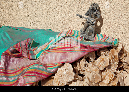 Kleine afrikanische Gitarre Sänger Statue auf einem Haufen Wüste stieg in einen Souvenir-Shop. Stockfoto