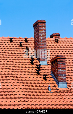 roten Ziegel Dach und Ziegel-Schornstein auf blauen Himmel Stockfoto