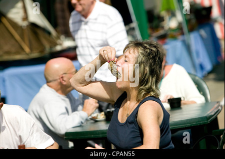 Frau, Essen, Austern, Whitstable, Hafen, Fisch, Markt, Kent, England, UK, Tourismus Stockfoto