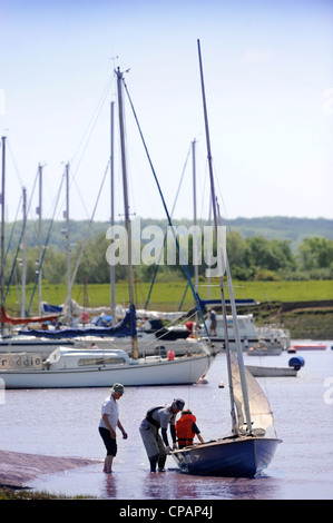 Ein Mann und eine junge bereiten ein Beiboot an einer Regatta Segeln auf den Fluss Severn in der Nähe von Thornbury, Gloucestershire UK Stockfoto