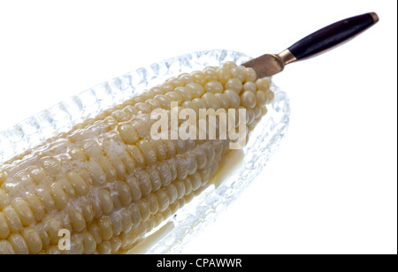 Butter schmelzen auf gekochten Mais Schale in Glasschale isoliert gegen weiß Stockfoto