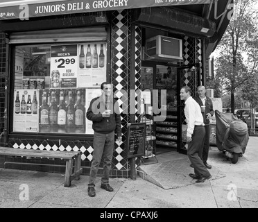 Der Besitzer und 2 Freunde stehen vor einer Bodega in Brooklyn, New York. Stockfoto