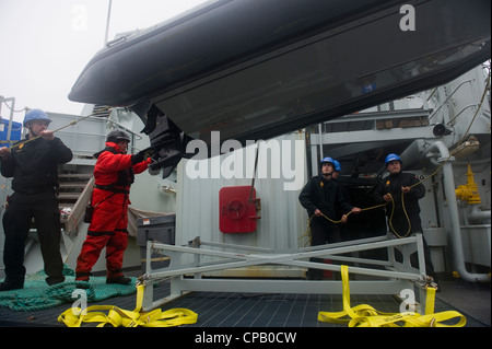 ) die Royal Canadian Navy Seemänner, die HMCS Summerside (MM 711) zugewiesen wurden, Bergen ein aufblasbares Boot mit starrem Rumpf, das während der Übung Frontier Sentinel 2012 am 5. Mai 2012 auf See vor Sydney, Nova Scotia, für Minengegenmaßnahmen verwendet wurde. Übung Frontier Sentinel ist eine kombinierte interagenturbezogene Übung, die die Joint Task Force Atlantic, die US-Küstenwache und das U.S. Navy Fleet Forces Command umfasst. Die Übung soll die bestehenden Pläne, Verträge und Standardverfahren für eine bilaterale Reaktion auf die Verteidigung und die Sicherheitsbedrohungen des maritimen Heimatlandes weiter entwickeln und validieren. Stockfoto