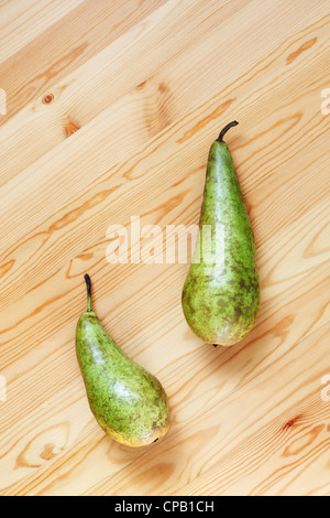 Zwei Birnen liegen auf einer Holzfläche. Stockfoto