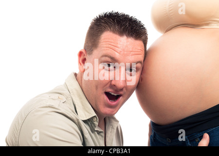 Überrascht werdender Vater und schwangeren Bauch, isoliert auf weißem Hintergrund. Stockfoto