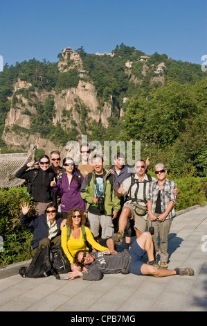 Eine Gruppe von europäischen Touristen posieren für die Kamera mit Thunderclap Gipfel des Berges Kongtong im Hintergrund. Stockfoto