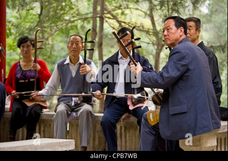 Eine chinesische Gruppe/Band Musiker spielen traditionellen chinesischen Musik (Erhu - chinesische Violine Hauptinstrument) am frühen Morgen in einem park Stockfoto