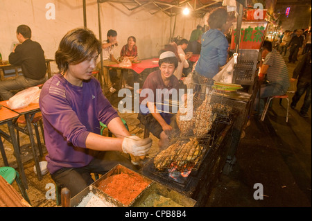 Vorbereitung gegrillt und gewürzten Fisch Snacks auf dem bekannten Zhengning Straße Essen street Nachtmarkt in Lanzhou. Stockfoto