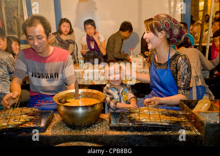 Vorbereitung gegrillt und gewürzten Fisch Snacks auf dem bekannten Zhengning Straße Essen street Nachtmarkt in Lanzhou. Stockfoto