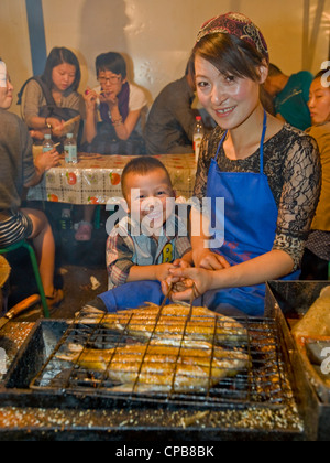 Vorbereitung gegrillt und gewürzten Fisch Snacks auf dem bekannten Zhengning Straße Essen street Nachtmarkt in Lanzhou. Stockfoto