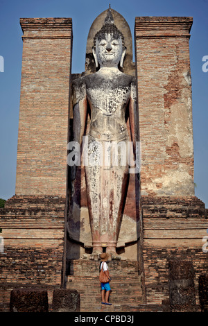 Tourist an der riesigen Buddha-Statue am Wat Mahathat Tempel Ruinen Sukhothai. Thailand. Stockfoto