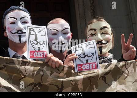 Besetzen, London UK. Anti Kapitalismus demonstration Teil einer globalen Tag der Aktion. 3 Demonstranten in anonyme Masken mit Plakaten "nicht gehorchen' Stockfoto