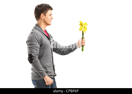 Ein lächelnder Mann hält eine Reihe von gelben Blüten isoliert auf weißem Hintergrund Stockfoto