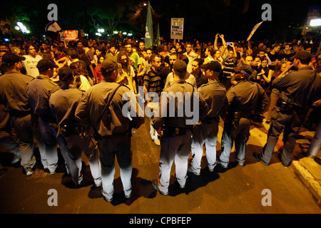 Israelische Polizisten, mit denen Demonstranten während der Lebenshaltungskosten Protest in Tel Aviv, Israel. Die soziale Gerechtigkeit Protest nannte auch die Zelte Protest waren eine Serie von Massendemonstrationen in Israel Anfang Juli 2011 mit Hunderttausenden Demonstranten aus einer Vielzahl von sozioökonomischen gegen die weiter steigenden Lebenshaltungskosten besonders Gehäuse. Stockfoto