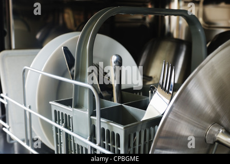 Gabeln, Messer, Teller, Tassen in der Spülmaschine Stockfoto